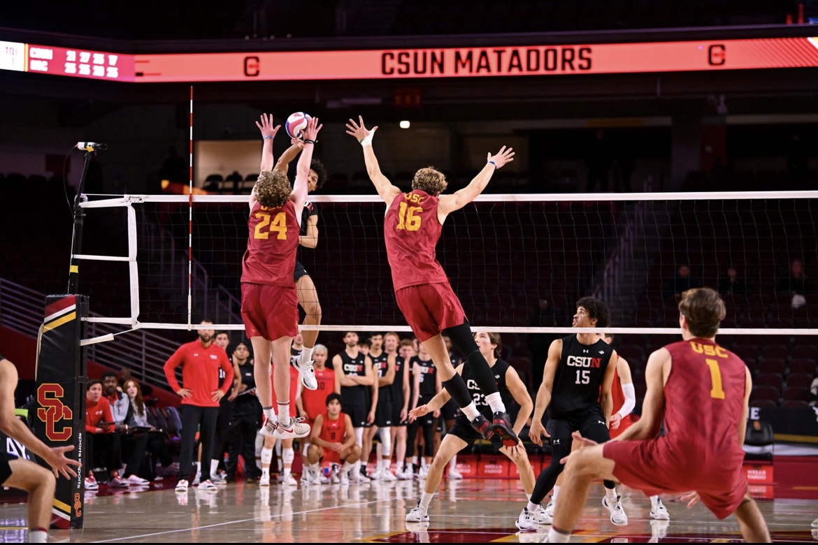 Two USC Men's Volleyball players blocking their opponent at the net